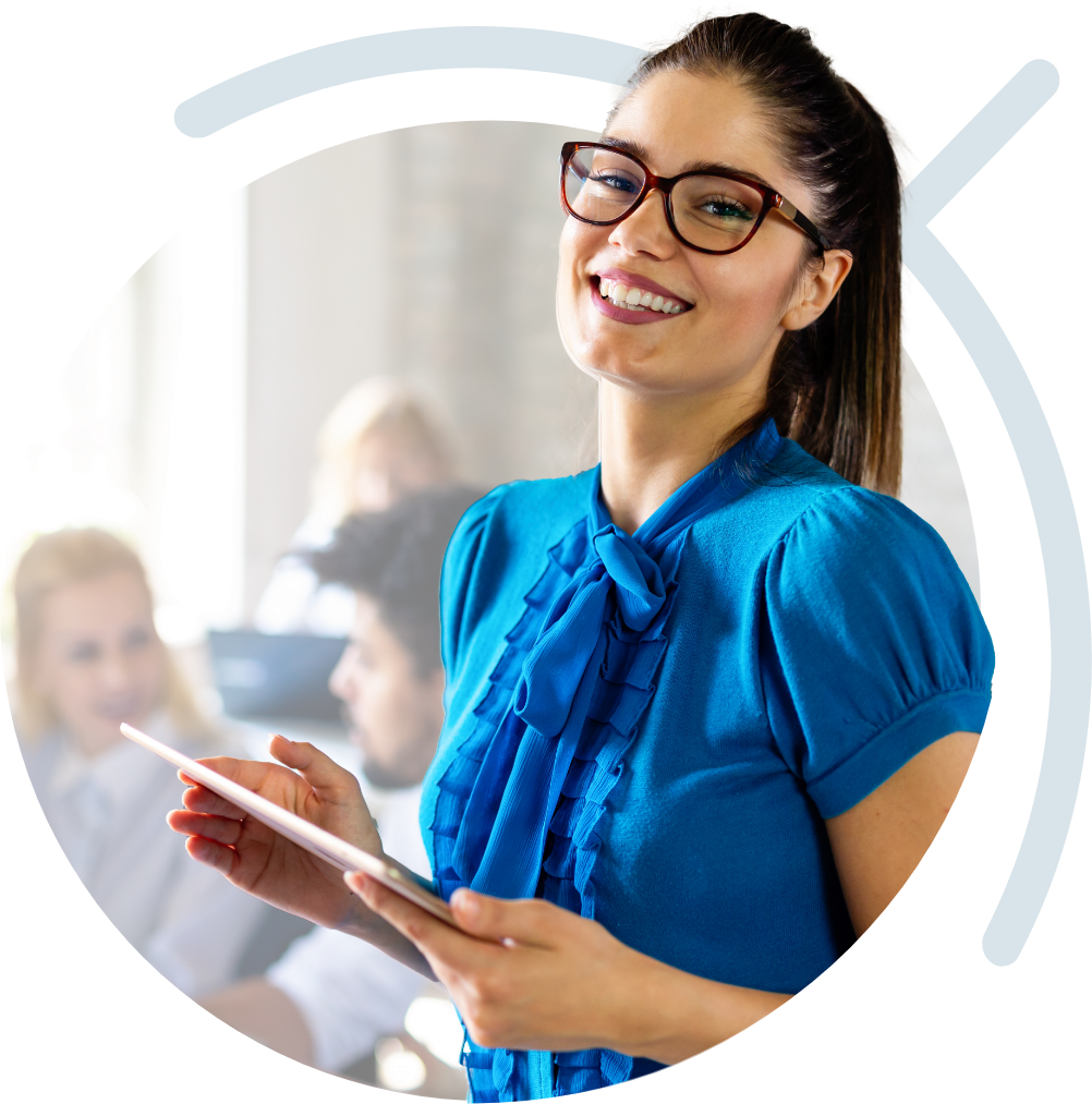 Woman smiling whilst working on her tablet at work.